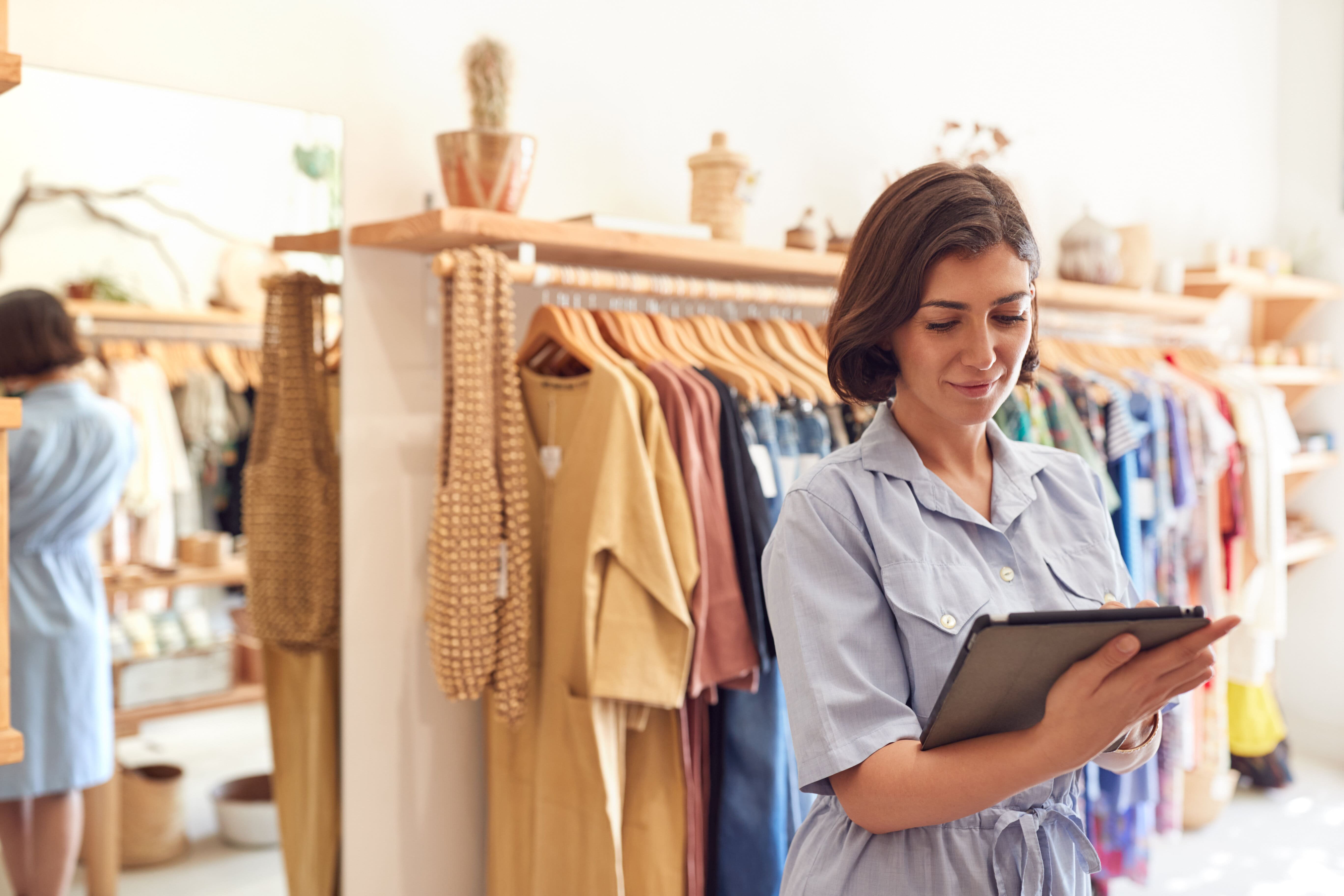 Female Owner Of Fashion Store Using Digital Tablet To Read About Retail Media