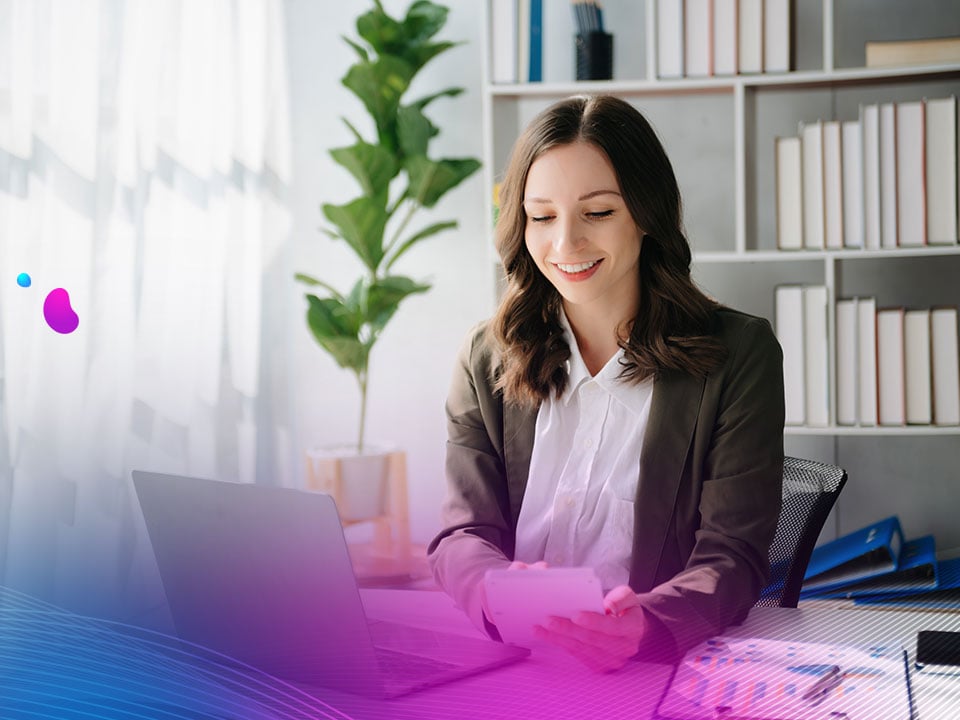 Woman sitting in an office who works in finance using dynamic content solutions on her laptop in front of her.